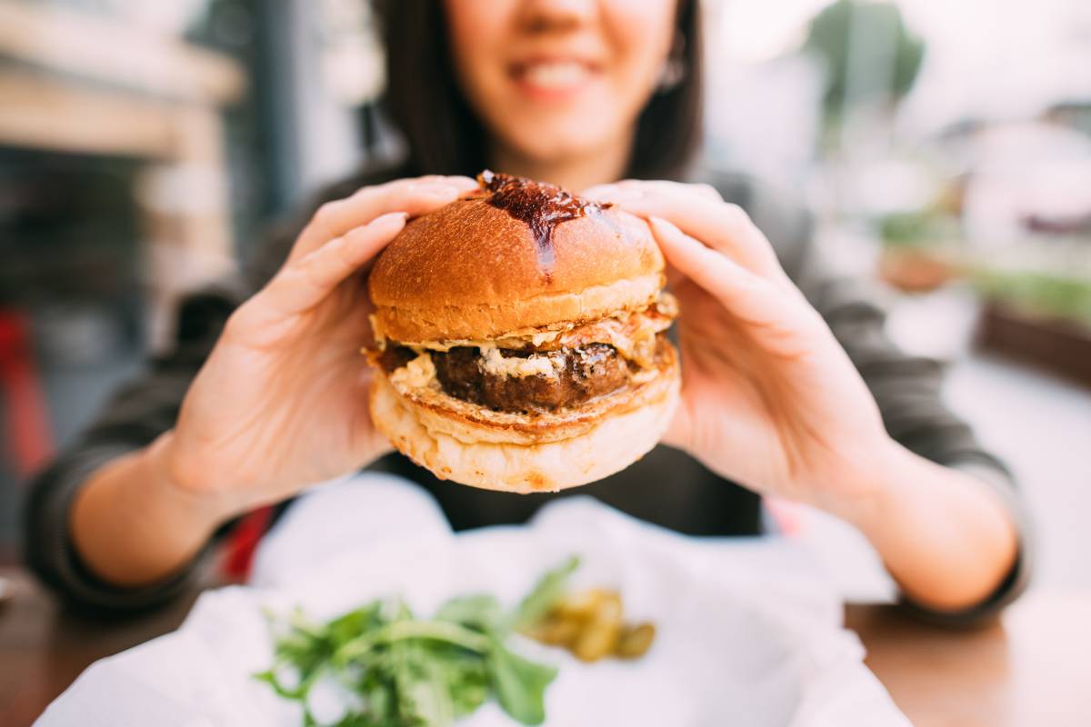 national burger day UK - a girl holding a burger in her hands