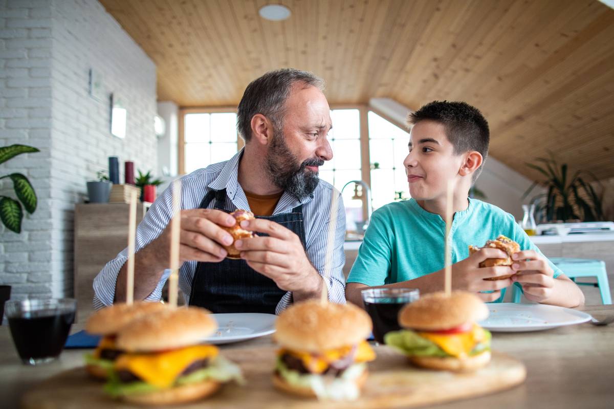 national burger day with family - a father and son enjoy the burger meal together