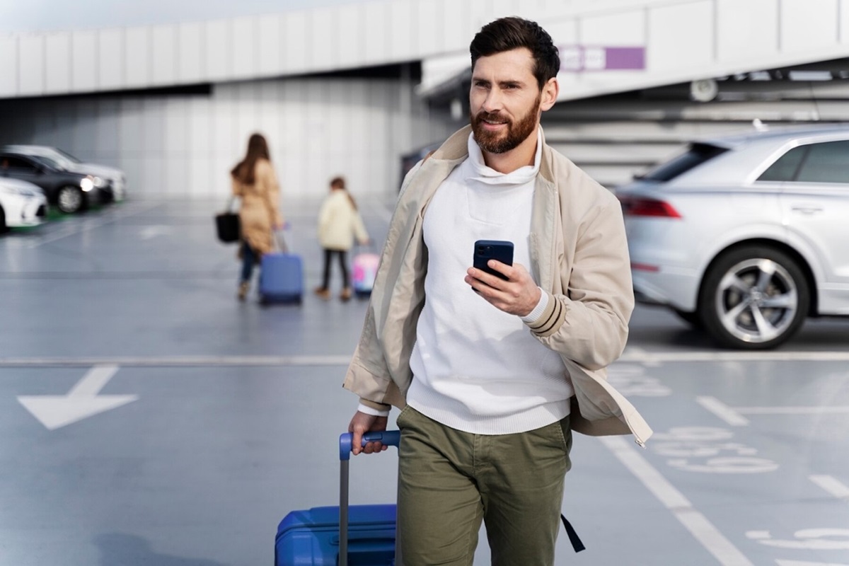 A Man Looking for His Rental Car in Bucharest Using His Cellphone